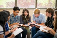 A group of high school students sitting in a circle, discussing a book